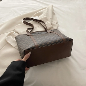 Brown vintage printed tote bag with leather handles on a minimalist background