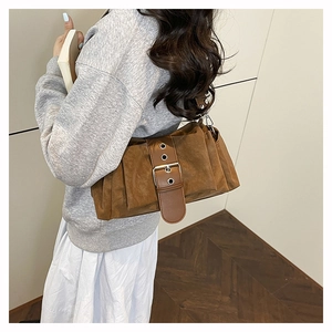 Détail du sac à bandoulière marron vintage avec boucle métal et design plissé
