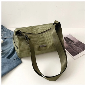 Détail du sac bandoulière en nylon vert olive à carreaux avec plaque logo métallique