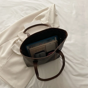Classic patterned tote bag with brown leather handles and spacious interior for essentials