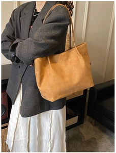 Detailed view of the fine texture and shoulder strap on a brown suede tote bag
