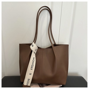 Detail of brown litchi pattern leather tote bag with vertical stitching and fashion ribbon