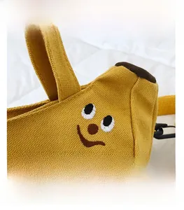 Gros plan du sac banane en toile jaune montrant la texture et la broderie sourire