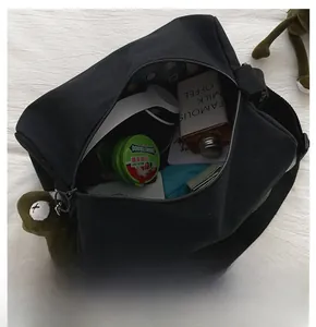 Dettaglio della grande capacità interna della borsa in tela nera con chiusura a zip