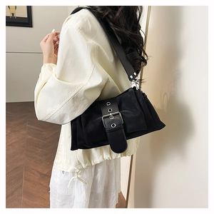 Detail of minimalist black matte crossbody bag with oversized silver buckle and wide strap