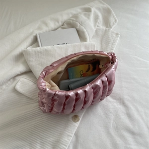 Rosa gesteppte Falten-Handtasche mit Glanz-Finish in stilvollem Lifestyle-Ambiente