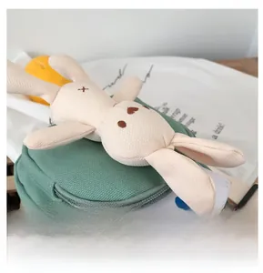 Détail du mini sac bandoulière en toile vert clair avec lapin en peluche et poche zippée avant