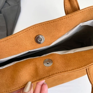 Brown suede tote bag with magnetic clasp closure and herringbone fabric lining