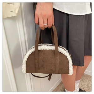 Detail of retro brown suede handbag with white faux shearling trim and top handles