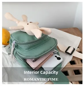 Capacité interne du sac en toile verte montrant un téléphone et un portefeuille