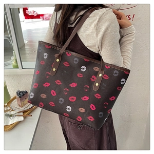Detail of large tote bag with red lip print and slim shoulder straps on a female model