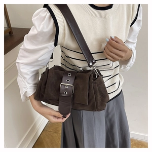 Detail of vintage brown suede shoulder bag with wide leather strap and metal buckle
