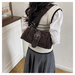 Vue détaillée du sac bandoulière en daim marron avec plis vintage et œillets argentés