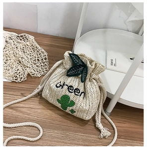 Detail of straw bucket bag with green cactus embroidery and cotton rope strap