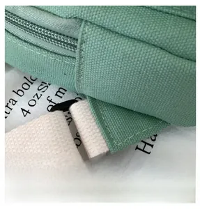 Détail du sac en toile vert menthe montrant la texture épaisse et la bandoulière blanche