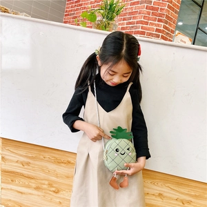 Détail du sac bandoulière ananas vert avec visage mignon et feuilles pour enfants