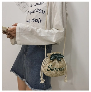 Detailed straw bucket bag with green Summer embroidery and leaf top accents