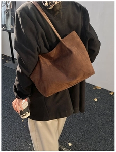 Dettaglio di una borsa tote grande in camoscio marrone con design minimalista ed elegante