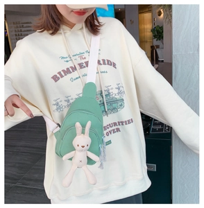 Détail d'un sac de poitrine en toile vert clair avec un adorable pendentif lapin beige