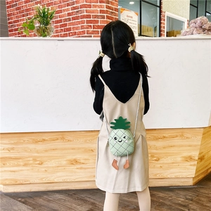 Vue arrière d'un enfant portant le joli sac bandoulière ananas vert avec détail de feuilles