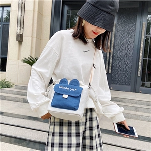 Detail of white canvas crossbody bucket bag featuring cute rabbit ears and drawstring closure