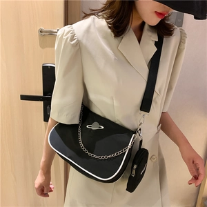 Detail of black nylon baguette bag with white planet pattern, metal chain and coin purse