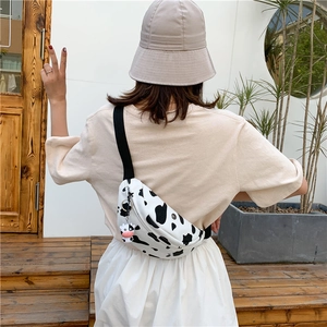 Close-up of cow print canvas chest bag with adjustable strap and cute cow charm