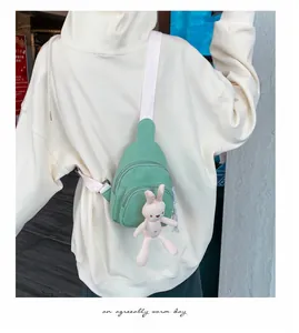 Vue détaillée du sac bandoulière en toile vert menthe avec un pendentif lapin mignon