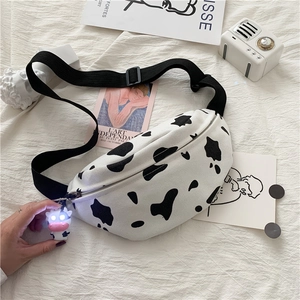 Detail of cow print canvas waist bag with adjustable strap and light-up cow charm accessory