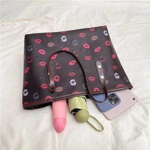 Brown tote bag with colorful lip prints and spacious interior holding everyday items