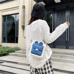 Close-up of a white and blue canvas crossbody bag with cute rabbit ears and print