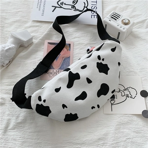 Detail shot of the canvas crossbody bag with black and white cow print and adjustable strap