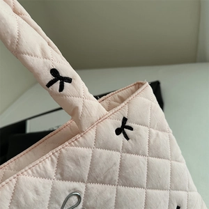 Pink quilted tote bag with diamond stitching and minimalist bow embroidery detail
