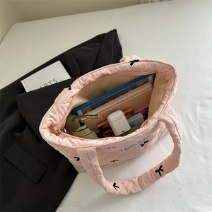 Pink quilted tote bag with black bow embroidery, showing large interior capacity for daily use