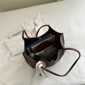 Large coffee brown leather tote bag with inner pouch, showing spacious storage capacity