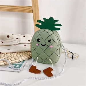 Détail du sac à bandoulière ananas avec visage souriant et texture en cuir vert