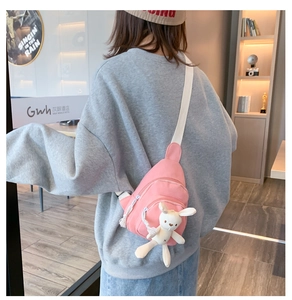 Détail du sac à bandoulière rose en toile avec charm lapin en peluche et sangle réglable