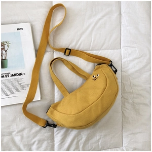 Détail du sac banane jaune en toile avec broderie sourire et sangle noire