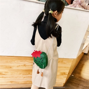 Rear view of a girl wearing a cute strawberry-shaped green crossbody bag with long strap