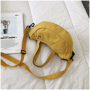 Vue détaillée du sac banane jaune en toile avec broderie visage drôle et bandoulière