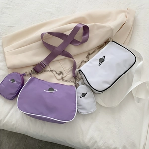 Detail of nylon crossbody bag with mini pouch, star pattern, and wide woven strap