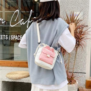 Detailed back view of a canvas crossbody bucket bag with cute 3D bunny ears and pink pocket