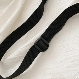 Detail of adjustable black nylon strap with plastic buckle for daisy canvas bag