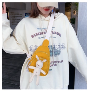 Sac bandoulière en toile jaune avec pendentif lapin en peluche porté par un mannequin