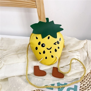 Close-up of yellow strawberry kids crossbody bag with cartoon face and leaf details