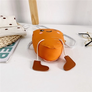 Détail du mignon sac à main orange pour enfant avec visage souriant et breloques bottes