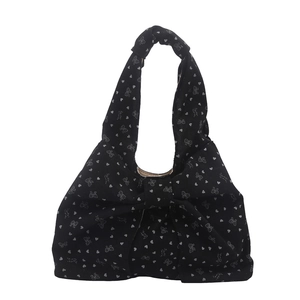 Black corduroy tote bag with heart and bow print featuring large central bow decoration