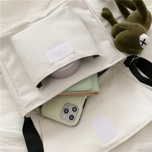 Interior view showing the large capacity of the beige canvas bag for phone and wallet