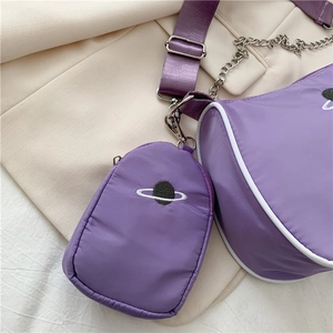 Close-up of purple nylon baguette bag set with silver chain and planet embroidery
