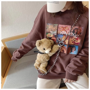 Brown sweatshirt with Lion King print and a plush teddy bear pendant on a chain